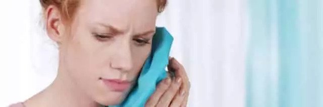 Frau mit Kalt-Kompresse gegen Zahnschmerzen